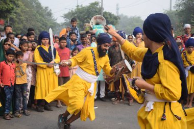 Delhi, Hindistan, 17 Kasım 2024 - Doğu Delhi bölgesinde Guru Nanak Dev, Nagar Kirtan 'ın doğum günü dolayısıyla geleneksel Nagar Kirtan, geleneksel Nagar geçit töreninde Sihler gatka ve dövüş sanatlarını sergiliyor
