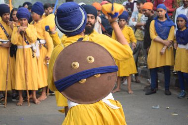 Delhi, Hindistan, 17 Kasım 2024 - Doğu Delhi bölgesinde Guru Nanak Dev, Nagar Kirtan 'ın doğum günü dolayısıyla geleneksel Nagar Kirtan, geleneksel Nagar geçit töreninde Sihler gatka ve dövüş sanatlarını sergiliyor
