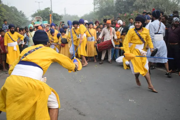 Delhi, Hindistan, 17 Kasım 2024 - Doğu Delhi bölgesinde Guru Nanak Dev, Nagar Kirtan 'ın doğum günü dolayısıyla geleneksel Nagar Kirtan, geleneksel Nagar geçit töreninde Sihler gatka ve dövüş sanatlarını sergiliyor