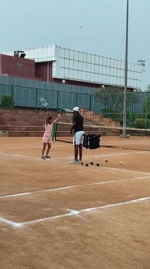 Delhi, Hindistan, 16 Nisan 2025 - Genç tenisçiler kil tenis kortunda antrenörlük yapıyor, küçük tenis oyuncuları yaklaşan turnuva için antrenman yapıyor