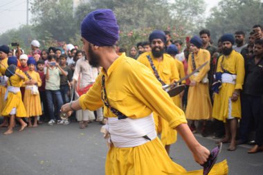 Delhi, Hindistan, 17 Kasım 2024 - Doğu Delhi bölgesinde Guru Nanak Dev, Nagar Kirtan 'ın doğum günü dolayısıyla geleneksel Nagar Kirtan, geleneksel Nagar geçit töreninde Sihler gatka ve dövüş sanatlarını sergiliyor