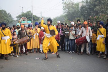 Delhi, Hindistan, 17 Kasım 2024 - Doğu Delhi bölgesinde Guru Nanak Dev, Nagar Kirtan 'ın doğum günü dolayısıyla geleneksel Nagar Kirtan, geleneksel Nagar geçit töreninde Sihler gatka ve dövüş sanatlarını sergiliyor