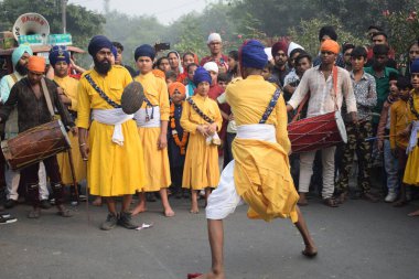 Delhi, Hindistan, 17 Kasım 2024 - Doğu Delhi bölgesinde Guru Nanak Dev, Nagar Kirtan 'ın doğum günü dolayısıyla geleneksel Nagar Kirtan, geleneksel Nagar geçit töreninde Sihler gatka ve dövüş sanatlarını sergiliyor