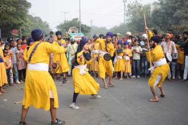 Delhi, Hindistan, 17 Kasım 2024 - Doğu Delhi bölgesinde Guru Nanak Dev, Nagar Kirtan 'ın doğum günü dolayısıyla geleneksel Nagar Kirtan, geleneksel Nagar geçit töreninde Sihler gatka ve dövüş sanatlarını sergiliyor