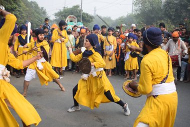 Delhi, Hindistan, 17 Kasım 2024 - Doğu Delhi bölgesinde Guru Nanak Dev, Nagar Kirtan 'ın doğum günü dolayısıyla geleneksel Nagar Kirtan, geleneksel Nagar geçit töreninde Sihler gatka ve dövüş sanatlarını sergiliyor