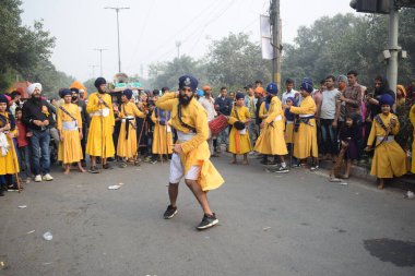 Delhi, Hindistan, 17 Kasım 2024 - Doğu Delhi bölgesinde Guru Nanak Dev, Nagar Kirtan 'ın doğum günü dolayısıyla geleneksel Nagar Kirtan, geleneksel Nagar geçit töreninde Sihler gatka ve dövüş sanatlarını sergiliyor