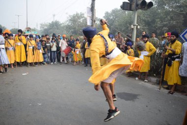 Delhi, Hindistan, 17 Kasım 2024 - Doğu Delhi bölgesinde Guru Nanak Dev, Nagar Kirtan 'ın doğum günü dolayısıyla geleneksel Nagar Kirtan, geleneksel Nagar geçit töreninde Sihler gatka ve dövüş sanatlarını sergiliyor