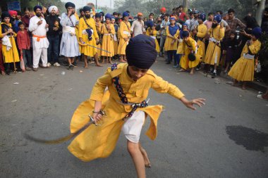 Delhi, Hindistan, 17 Kasım 2024 - Doğu Delhi bölgesinde Guru Nanak Dev, Nagar Kirtan 'ın doğum günü dolayısıyla geleneksel Nagar Kirtan, geleneksel Nagar geçit töreninde Sihler gatka ve dövüş sanatlarını sergiliyor