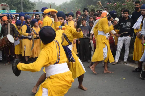 Delhi, Hindistan, 17 Kasım 2024 - Doğu Delhi bölgesinde Guru Nanak Dev, Nagar Kirtan 'ın doğum günü dolayısıyla geleneksel Nagar Kirtan, geleneksel Nagar geçit töreninde Sihler gatka ve dövüş sanatlarını sergiliyor