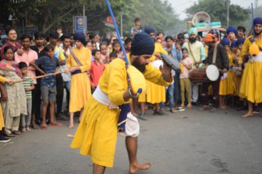 Delhi, Hindistan, 17 Kasım 2024 - Doğu Delhi bölgesinde Guru Nanak Dev, Nagar Kirtan 'ın doğum günü dolayısıyla geleneksel Nagar Kirtan, geleneksel Nagar geçit töreninde Sihler gatka ve dövüş sanatlarını sergiliyor
