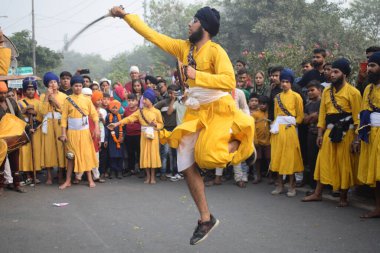 Delhi, Hindistan, 17 Kasım 2024 - Doğu Delhi bölgesinde Guru Nanak Dev, Nagar Kirtan 'ın doğum günü dolayısıyla geleneksel Nagar Kirtan, geleneksel Nagar geçit töreninde Sihler gatka ve dövüş sanatlarını sergiliyor