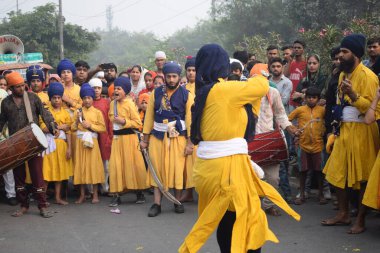 Delhi, Hindistan, 17 Kasım 2024 - Doğu Delhi bölgesinde Guru Nanak Dev, Nagar Kirtan 'ın doğum günü dolayısıyla geleneksel Nagar Kirtan, geleneksel Nagar geçit töreninde Sihler gatka ve dövüş sanatlarını sergiliyor