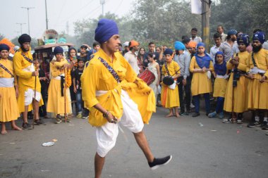 Delhi, Hindistan, 17 Kasım 2024 - Doğu Delhi bölgesinde Guru Nanak Dev, Nagar Kirtan 'ın doğum günü dolayısıyla geleneksel Nagar Kirtan, geleneksel Nagar geçit töreninde Sihler gatka ve dövüş sanatlarını sergiliyor