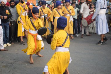 Delhi, Hindistan, 17 Kasım 2024 - Doğu Delhi bölgesinde Guru Nanak Dev, Nagar Kirtan 'ın doğum günü dolayısıyla geleneksel Nagar Kirtan, geleneksel Nagar geçit töreninde Sihler gatka ve dövüş sanatlarını sergiliyor