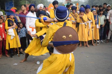 Delhi, Hindistan, 17 Kasım 2024 - Doğu Delhi bölgesinde Guru Nanak Dev, Nagar Kirtan 'ın doğum günü dolayısıyla geleneksel Nagar Kirtan, geleneksel Nagar geçit töreninde Sihler gatka ve dövüş sanatlarını sergiliyor