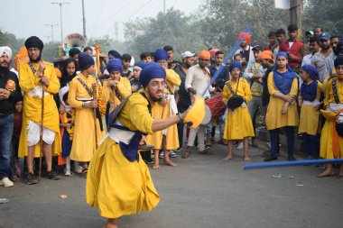Delhi, Hindistan, 17 Kasım 2024 - Doğu Delhi bölgesinde Guru Nanak Dev, Nagar Kirtan 'ın doğum günü dolayısıyla geleneksel Nagar Kirtan, geleneksel Nagar geçit töreninde Sihler gatka ve dövüş sanatlarını sergiliyor
