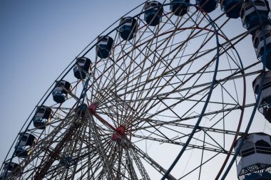 Delhi, Hindistan 'da Dussehra Mela sırasında çok renkli Dev Tekerlek' in yakın çekimi. Dev tekerlek salıncağının alt görüntüsü. Akşam vakti renkli kamaraları olan dönme dolap..