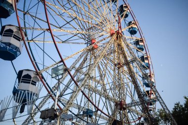 Delhi, Hindistan 'da Dussehra Mela sırasında çok renkli Dev Tekerlek' in yakın çekimi. Dev tekerlek salıncağının alt görüntüsü. Akşam vakti renkli kamaraları olan dönme dolap..