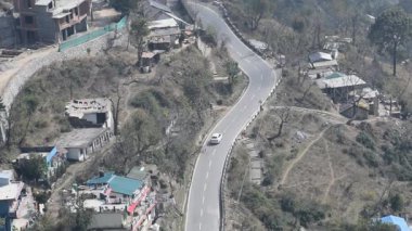 Nainital, Uttarakhand, Hindistan 'daki dağlarda giden trafik araçlarının hava görüntüsü, trafik araçlarının hareketi için dağın tepesinden görüntü. 