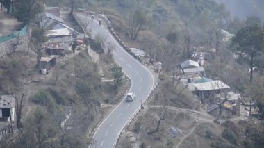 Nainital, Uttarakhand, Hindistan 'daki dağlarda giden trafik araçlarının hava görüntüsü, trafik araçlarının hareketi için dağın tepesinden görüntü. 