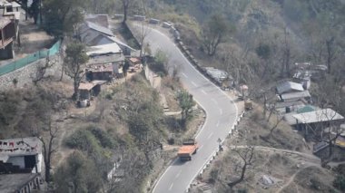 Nainital, Uttarakhand, Hindistan 'daki dağlarda giden trafik araçlarının hava görüntüsü, trafik araçlarının hareketi için dağın tepesinden görüntü. 