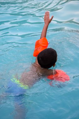 Havuzda yüzen mutlu Hintli çocuk, sıcak yaz tatillerinde hava tüpüyle birlikte yüzen çocuk, büyük bir havuzda yüzen çocuk..