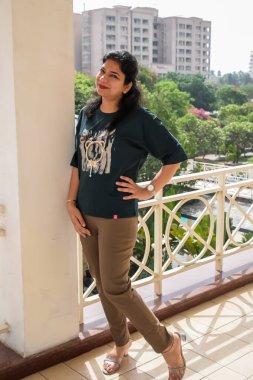 Fotoşop için poz veren genç ve güzel Hintli bayan, kendinden emin Asyalı kadın güneş ışığı altında fotoşop yapıyor.