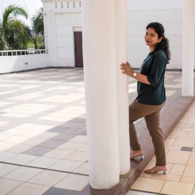 Fotoşop için poz veren genç ve güzel Hintli bayan, kendinden emin Asyalı kadın güneş ışığı altında fotoşop yapıyor.