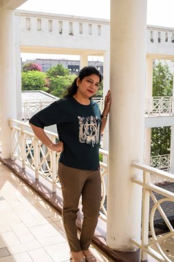 Fotoşop için poz veren genç ve güzel Hintli bayan, kendinden emin Asyalı kadın güneş ışığı altında fotoşop yapıyor.