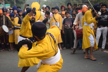 Delhi, Hindistan, 17 Kasım 2024 - Doğu Delhi bölgesinde Guru Nanak Dev, Nagar Kirtan 'ın doğum günü dolayısıyla geleneksel Nagar Kirtan, geleneksel Nagar geçit töreninde Sihler gatka ve dövüş sanatlarını sergiliyor