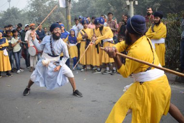 Delhi, Hindistan, 17 Kasım 2024 - Doğu Delhi bölgesinde Guru Nanak Dev, Nagar Kirtan 'ın doğum günü dolayısıyla geleneksel Nagar Kirtan, geleneksel Nagar geçit töreninde Sihler gatka ve dövüş sanatlarını sergiliyor