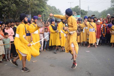 Delhi, Hindistan, 17 Kasım 2024 - Doğu Delhi bölgesinde Guru Nanak Dev, Nagar Kirtan 'ın doğum günü dolayısıyla geleneksel Nagar Kirtan, geleneksel Nagar geçit töreninde Sihler gatka ve dövüş sanatlarını sergiliyor