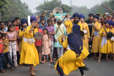 Delhi, Hindistan, 17 Kasım 2024 - Doğu Delhi bölgesinde Guru Nanak Dev, Nagar Kirtan 'ın doğum günü dolayısıyla geleneksel Nagar Kirtan, geleneksel Nagar geçit töreninde Sihler gatka ve dövüş sanatlarını sergiliyor