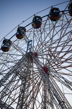 Delhi, Hindistan 'da Dussehra Mela sırasında çok renkli Dev Tekerlek' in yakın çekimi. Dev tekerlek salıncağının alt görüntüsü. Akşam vakti renkli kamaraları olan dönme dolap..