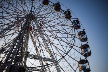 Delhi, Hindistan 'da Dussehra Mela sırasında çok renkli Dev Tekerlek' in yakın çekimi. Dev tekerlek salıncağının alt görüntüsü. Akşam vakti renkli kamaraları olan dönme dolap..