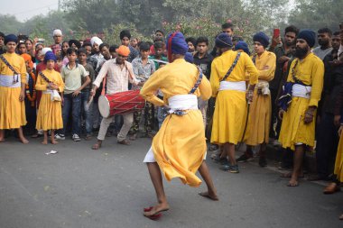 Delhi, Hindistan, 17 Kasım 2024 - Doğu Delhi bölgesinde Guru Nanak Dev, Nagar Kirtan 'ın doğum günü dolayısıyla geleneksel Nagar Kirtan, geleneksel Nagar geçit töreninde Sihler gatka ve dövüş sanatlarını sergiliyor