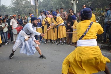Delhi, Hindistan, 17 Kasım 2024 - Doğu Delhi bölgesinde Guru Nanak Dev, Nagar Kirtan 'ın doğum günü dolayısıyla geleneksel Nagar Kirtan, geleneksel Nagar geçit töreninde Sihler gatka ve dövüş sanatlarını sergiliyor