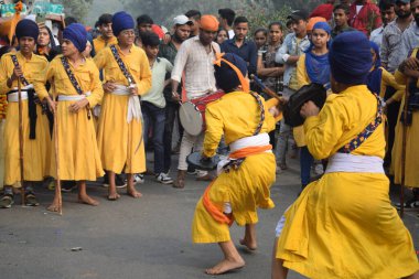 Delhi, Hindistan, 17 Kasım 2024 - Doğu Delhi bölgesinde Guru Nanak Dev, Nagar Kirtan 'ın doğum günü dolayısıyla geleneksel Nagar Kirtan, geleneksel Nagar geçit töreninde Sihler gatka ve dövüş sanatlarını sergiliyor
