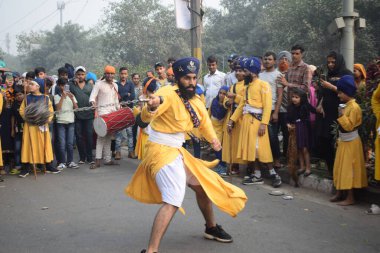 Delhi, Hindistan, 17 Kasım 2024 - Doğu Delhi bölgesinde Guru Nanak Dev, Nagar Kirtan 'ın doğum günü dolayısıyla geleneksel Nagar Kirtan, geleneksel Nagar geçit töreninde Sihler gatka ve dövüş sanatlarını sergiliyor