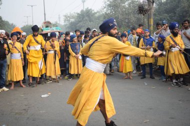 Delhi, Hindistan, 17 Kasım 2024 - Doğu Delhi bölgesinde Guru Nanak Dev, Nagar Kirtan 'ın doğum günü dolayısıyla geleneksel Nagar Kirtan, geleneksel Nagar geçit töreninde Sihler gatka ve dövüş sanatlarını sergiliyor