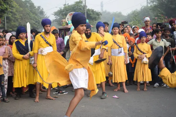 Delhi, Hindistan, 17 Kasım 2024 - Doğu Delhi bölgesinde Guru Nanak Dev, Nagar Kirtan 'ın doğum günü dolayısıyla geleneksel Nagar Kirtan, geleneksel Nagar geçit töreninde Sihler gatka ve dövüş sanatlarını sergiliyor