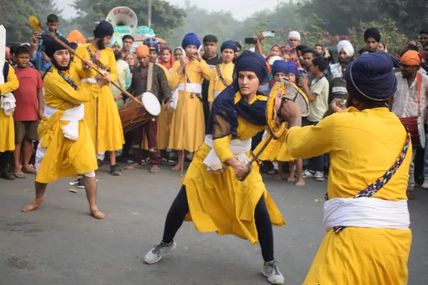 Delhi, Hindistan, 17 Kasım 2024 - Doğu Delhi bölgesinde Guru Nanak Dev, Nagar Kirtan 'ın doğum günü dolayısıyla geleneksel Nagar Kirtan, geleneksel Nagar geçit töreninde Sihler gatka ve dövüş sanatlarını sergiliyor