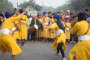 Delhi, Hindistan, 17 Kasım 2024 - Doğu Delhi bölgesinde Guru Nanak Dev, Nagar Kirtan 'ın doğum günü dolayısıyla geleneksel Nagar Kirtan, geleneksel Nagar geçit töreninde Sihler gatka ve dövüş sanatlarını sergiliyor