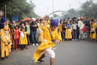 Delhi, Hindistan, 17 Kasım 2024 - Doğu Delhi bölgesinde Guru Nanak Dev, Nagar Kirtan 'ın doğum günü dolayısıyla geleneksel Nagar Kirtan, geleneksel Nagar geçit töreninde Sihler gatka ve dövüş sanatlarını sergiliyor