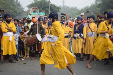 Delhi, Hindistan, 17 Kasım 2024 - Doğu Delhi bölgesinde Guru Nanak Dev, Nagar Kirtan 'ın doğum günü dolayısıyla geleneksel Nagar Kirtan, geleneksel Nagar geçit töreninde Sihler gatka ve dövüş sanatlarını sergiliyor