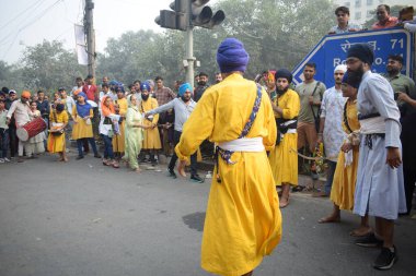 Delhi, Hindistan, 17 Kasım 2024 - Doğu Delhi bölgesinde Guru Nanak Dev, Nagar Kirtan 'ın doğum günü dolayısıyla geleneksel Nagar Kirtan, geleneksel Nagar geçit töreninde Sihler gatka ve dövüş sanatlarını sergiliyor