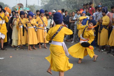 Delhi, Hindistan, 17 Kasım 2024 - Doğu Delhi bölgesinde Guru Nanak Dev, Nagar Kirtan 'ın doğum günü dolayısıyla geleneksel Nagar Kirtan, geleneksel Nagar geçit töreninde Sihler gatka ve dövüş sanatlarını sergiliyor