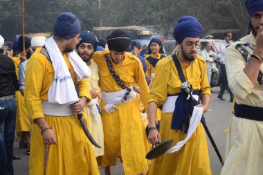 Delhi, Hindistan, 17 Kasım 2024 - Doğu Delhi bölgesinde Guru Nanak Dev, Nagar Kirtan 'ın doğum günü dolayısıyla geleneksel Nagar Kirtan, geleneksel Nagar geçit töreninde Sihler gatka ve dövüş sanatlarını sergiliyor