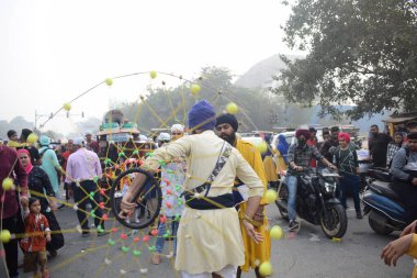 Delhi, Hindistan, 17 Kasım 2024 - Doğu Delhi bölgesinde Guru Nanak Dev, Nagar Kirtan 'ın doğum günü dolayısıyla geleneksel Nagar Kirtan, geleneksel Nagar geçit töreninde Sihler gatka ve dövüş sanatlarını sergiliyor