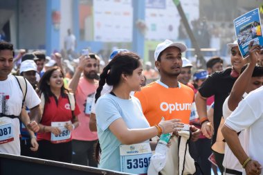 Yeni Delhi, Hindistan - 20 Ekim 2024 - Bitmek üzere olan maraton katılımcılarının bitiş çizgisini geçmek üzere olan Delhi Yarı Maratonu 2024